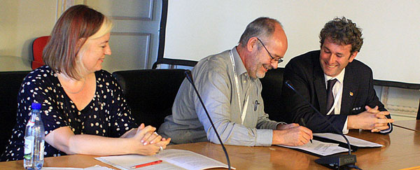 Bert Lenten, UNEP/CMS, and Tom Barry, CAFF, signed an agreement between the African-Eurasian Waterbird Agreement and CAFF while Barbara Ruis, UNEP, looked on. Photo: IISD