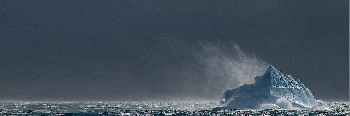 Wind blows over iceberg in ocean